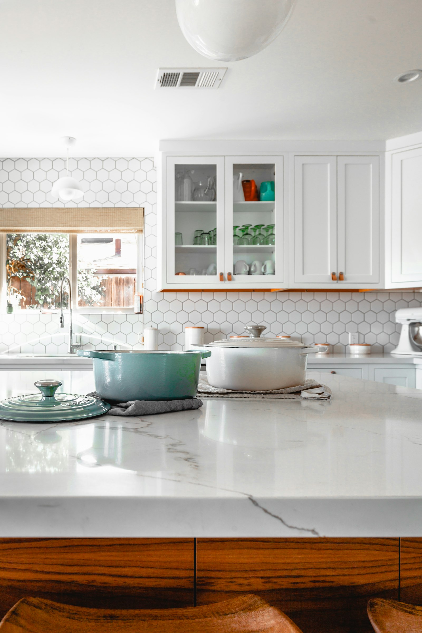 A bright home kitchen with cookware ready on the island